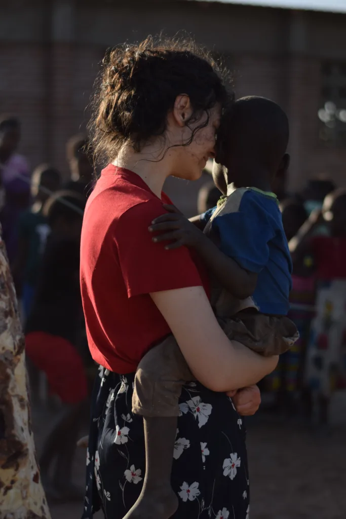 Denisa Codrea holding a child in Malawi, Africa.
